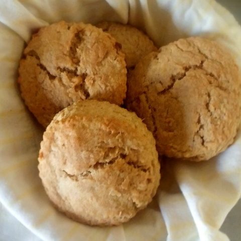 four biscuits arranged in a bowl with a yellow cloth