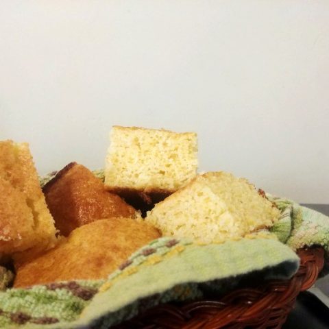 cornbread in a basket with a green cloth