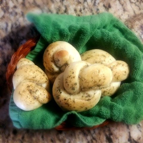 garlic knots arranged on a green cloth in a basket