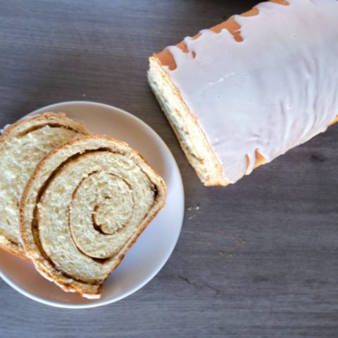 overhead shot of a slice of cinnamon swirl bread and whole cinnamon bread loaf