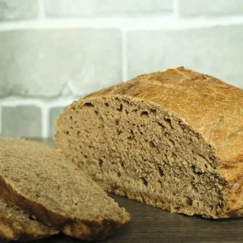 partially sliced loaf of wheat bread