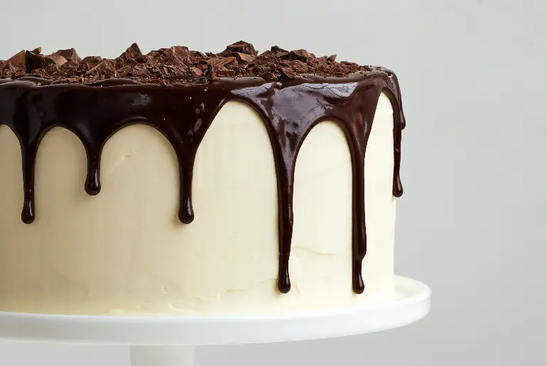 white frosted cake with chocolate ganache drip