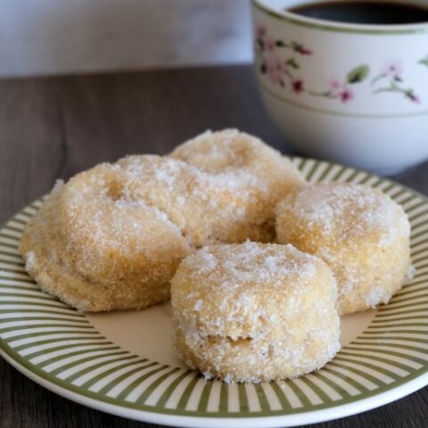 pastries on a plate next to a mug of coffee