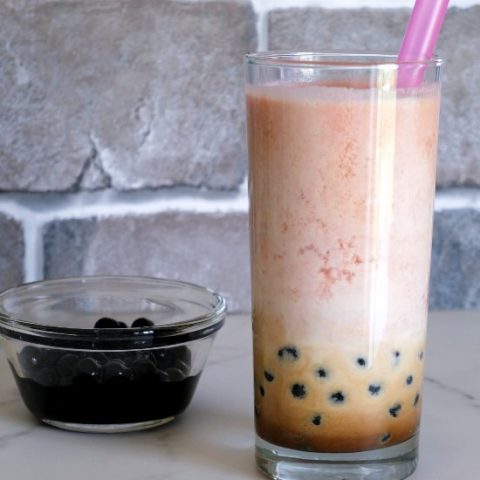 tall glass of bubble tea with pink straw
