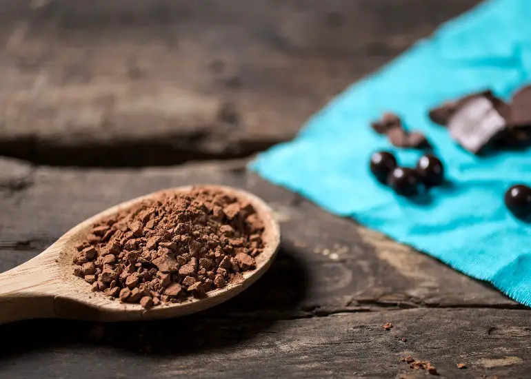 cocoa in a spoon on a wood surface