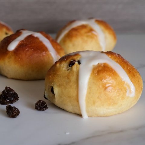 hot cross bun surrounded by raisins