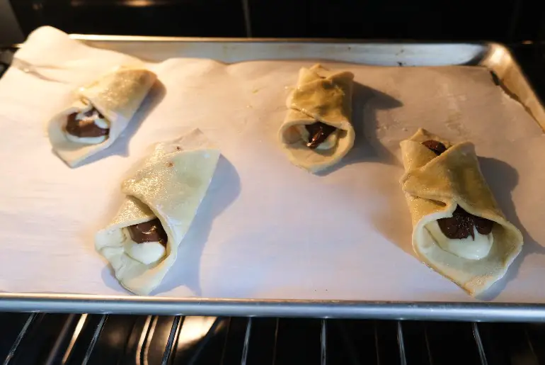 nutella danishes on baking sheet in the oven