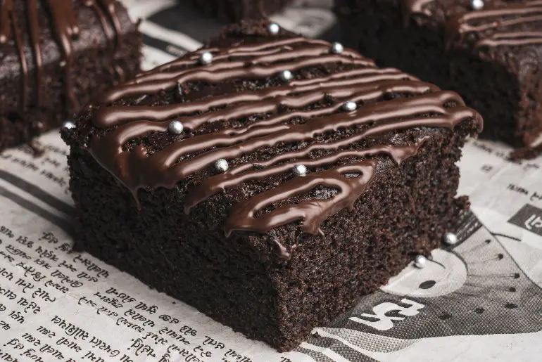 chocolate-drizzled brownie on a newspaper