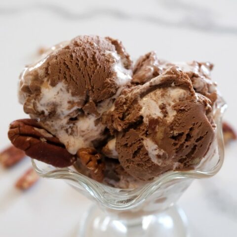 rocky road ice cream in a glass dish garnished with pecans