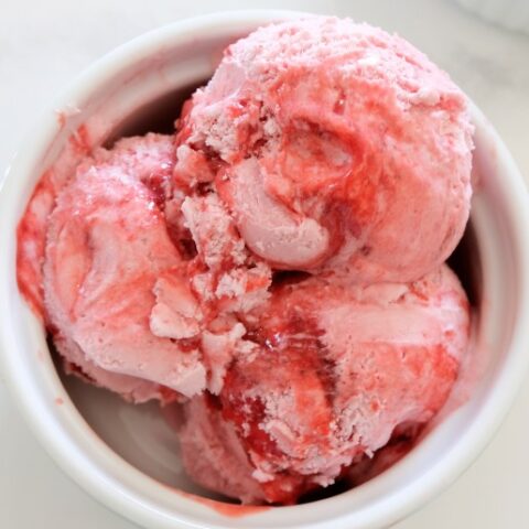 3 scoops of strawberry ice cream in white bowl